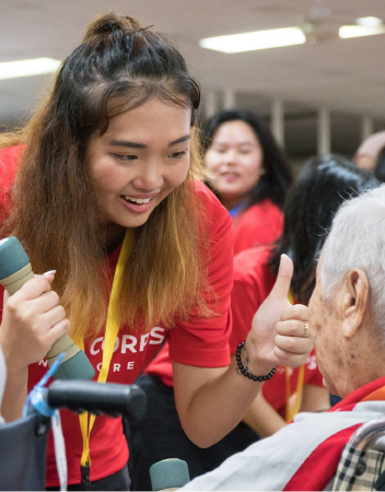 Smiling youth volunteer interacting with senior