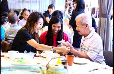 The volunteers helping the seniors put on gloves before rolling the popiah