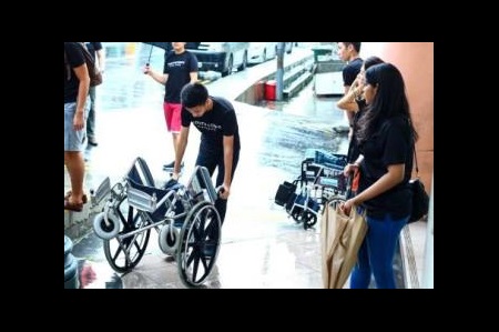 Volunteers preparing the wheelchairs for the seniors despite the rain